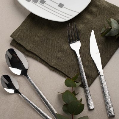 cutlery in styled table setting with plate and serviette