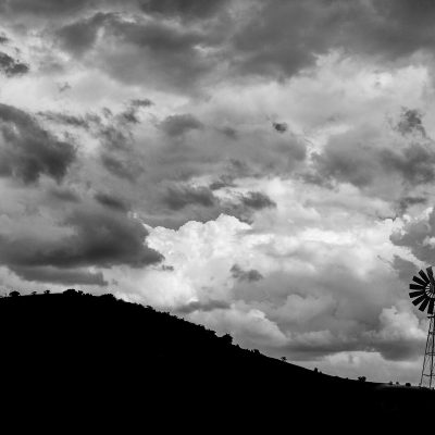 Black and white image with a view of mountains and windmill